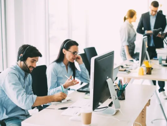 A office with four people working at the desks.