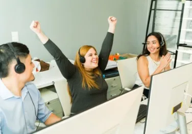 A telemarketer celebrating with her arms up.